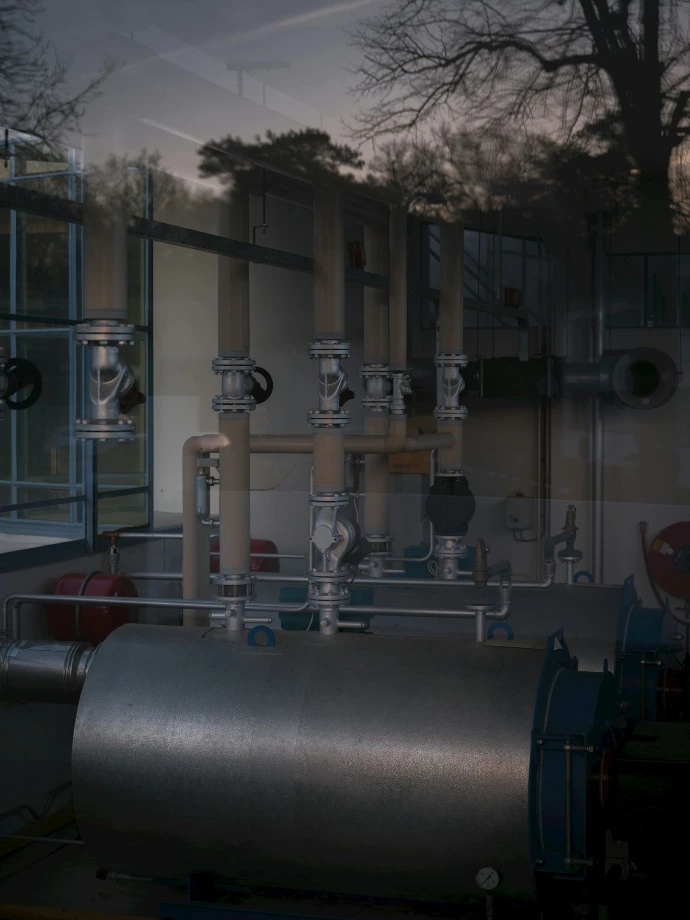 Industrial machinery with pipes and tanks indoors.